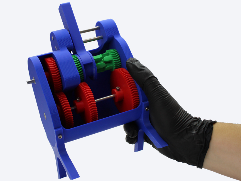 Hand holding multicoloured 3D printed gearbox